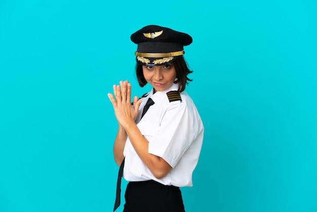 Young airplane pilot over isolated blue background scheming something