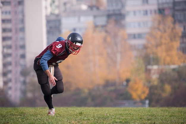 Giovane giocatore di football americano in azione durante l'allenamento sul campo