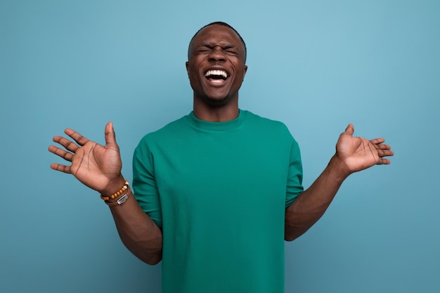 Young american guy dressed in a basic tshirt with his hands raised for understanding against the