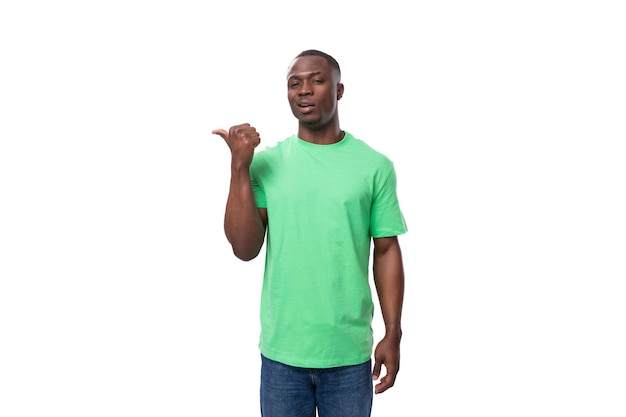 A young american guy dressed in a mint tshirt points with his hand to the presence of news and