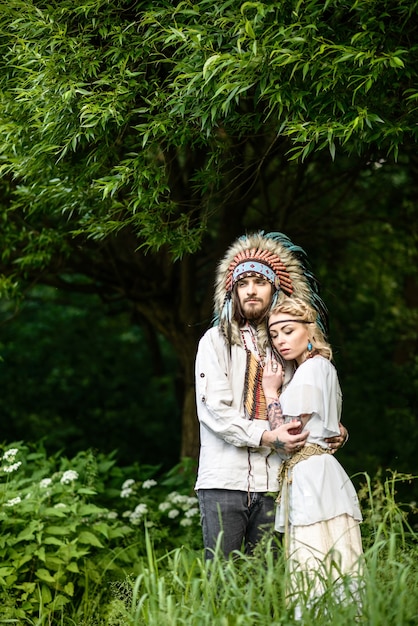 Young American Indian paar knuffelen in het bos