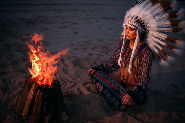 Young American Indian woman against fire