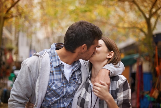 Фото Молодые и влюбленные нежная молодая пара целуется, когда они идут по улице
