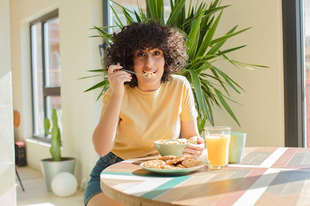 写真 家で朝食をとっている若くてきれいな女性