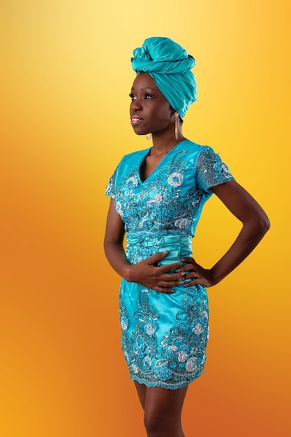 Young Angolan girl wearing dress and turban studio photo on a black background