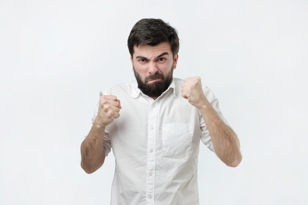 Young angry hispanic man is angry clenching his fists