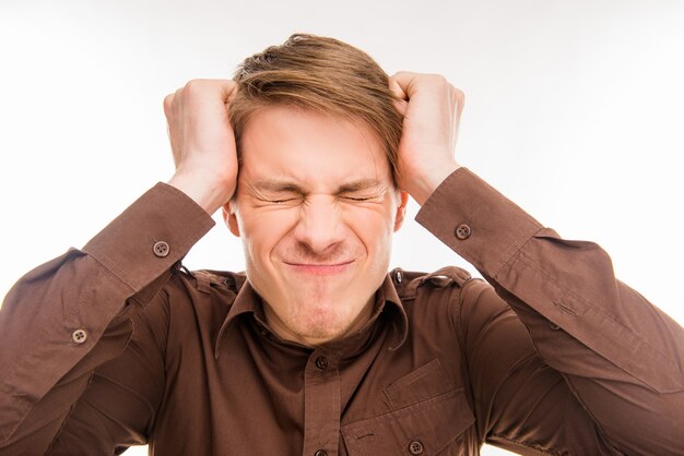 Young angry man touching his head