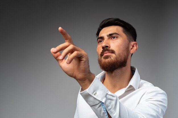 Young Arab businessman working with virtual screen over grey background