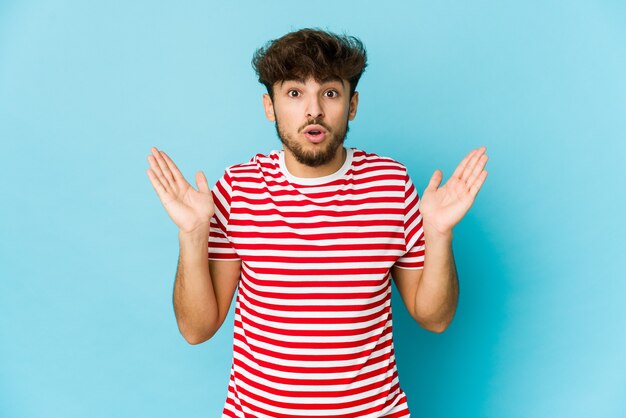 Photo young arab man on blue surprised and shocked.