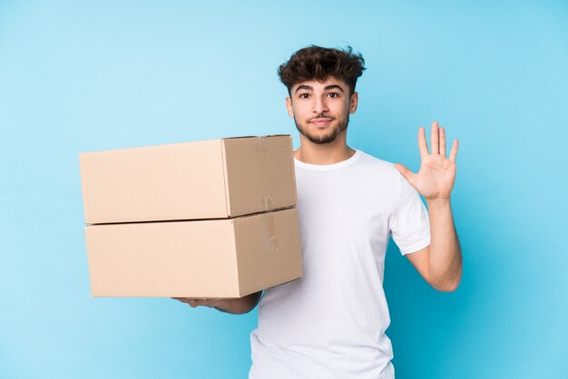 Young arab man holding boxes