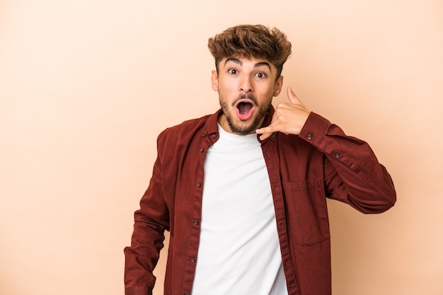 Young arab man isolated on beige background laughing about something, covering mouth with hands.