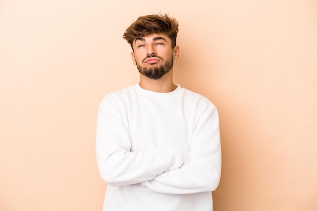 Young arab man isolated on beige background tired of a repetitive task.