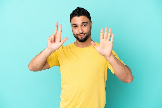 Young arab man isolated on blue background counting eight with fingers