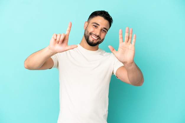 Young arab man isolated on blue background counting seven with fingers