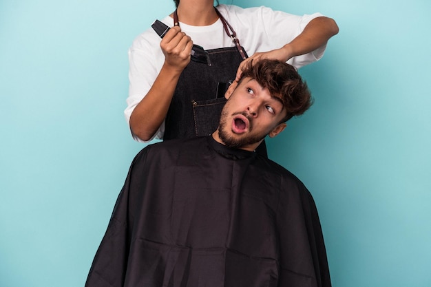 Young arab man ready to get a haircut isolated on blue background