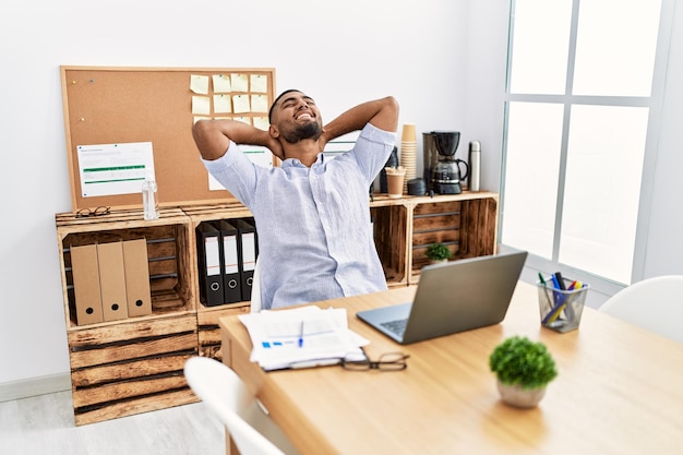 Photo young arab man relaxed with hands on head working at office