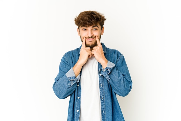 Young arab man on white background doubting between two options.