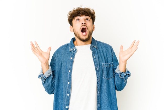 Young arab man on white screaming to the sky, looking up, frustrated.