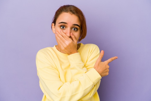 Young arab mixed race woman pointing to the side