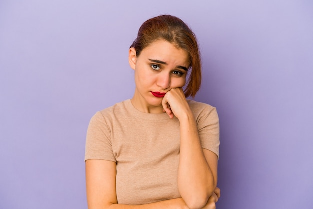 Young arab mixed race woman who feels sad and pensive, looking at copy space.