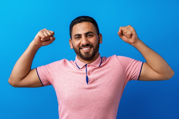 Young arab successful man celebrating triumph in studio