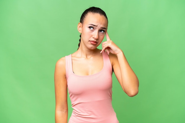 Young Arab woman over isolated background making the gesture of madness putting finger on the head