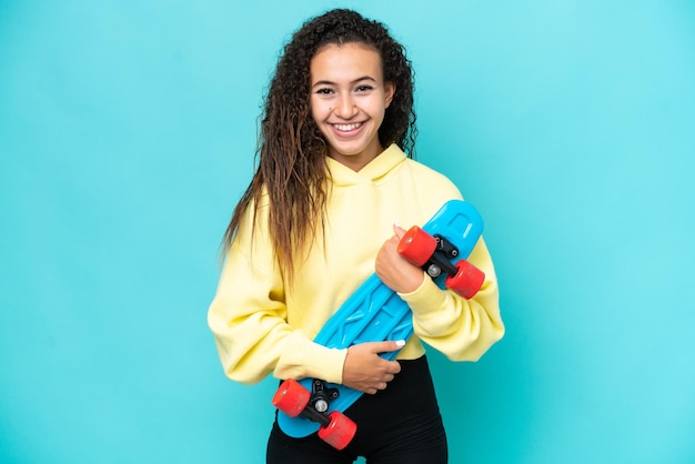 Young Arab woman isolated on blue background with a skate with happy expression