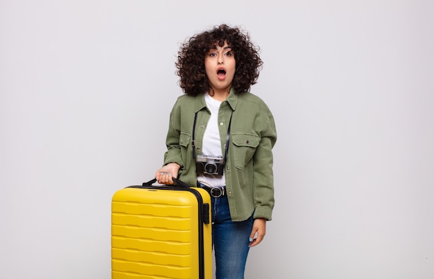 Young arab woman looking very shocked or surprised, staring with open mouth saying wow travel concept