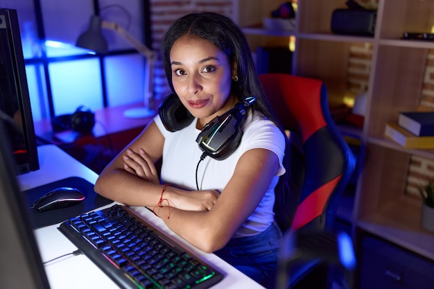 Photo young arab woman streamer smiling confident sitting with arms crossed gesture at gaming room