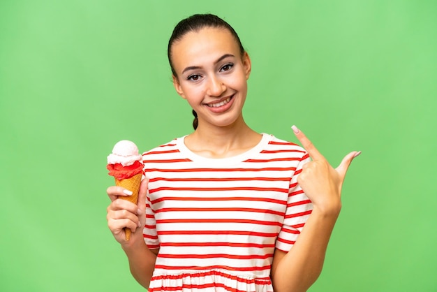 Young arab woman with a cornet ice cream over isolated background giving a thumbs up gesture