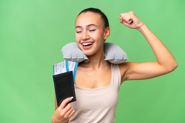 Young Arab woman with Inflatable Travel Pillow over isolated background celebrating a victory