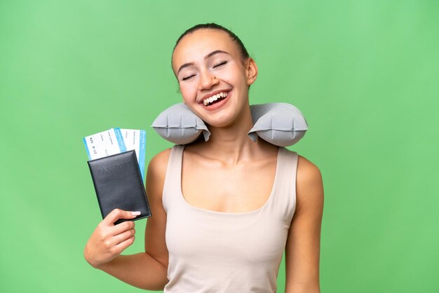 Young Arab woman with Inflatable Travel Pillow over isolated background laughing