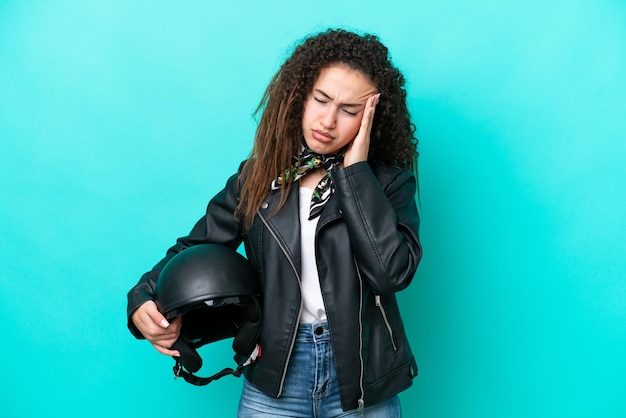 Young Arab woman with a motorcycle helmet isolated on blue background with headache