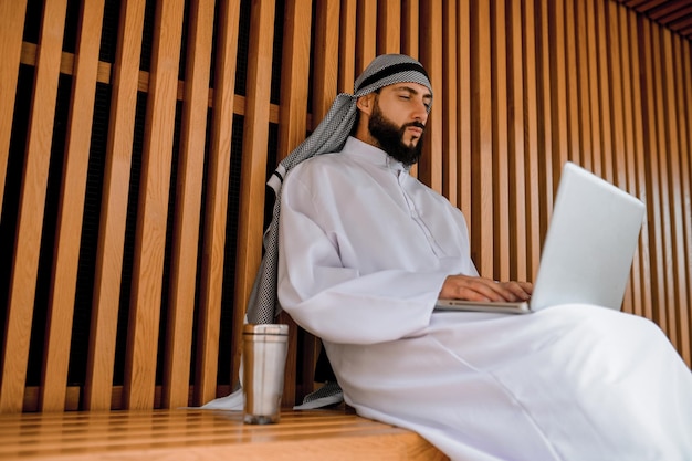 Young arabian businessman working on a laptop and looking involved