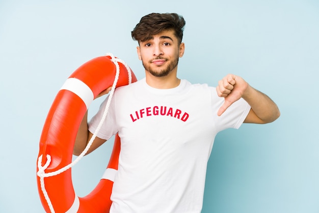 Young arabian lifeguard man isolated  showing a dislike gesture, thumbs down.