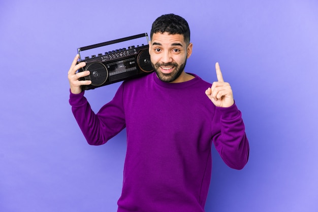 Giovane uomo arabo che tiene una cassetta radio