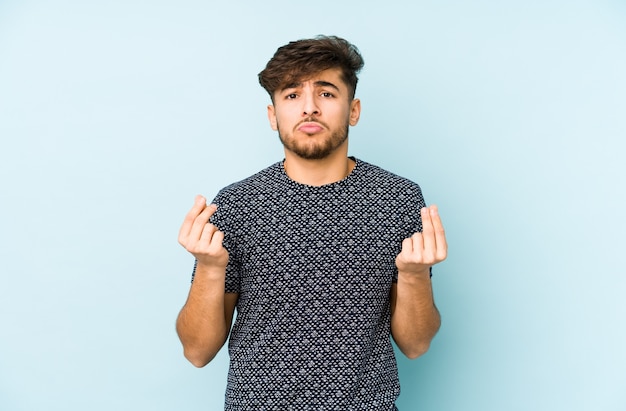 Young arabian man isolated on blue showing that she has no money.