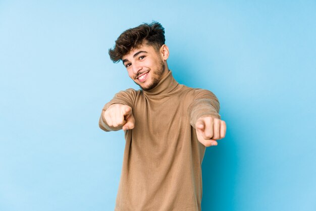 Young arabian man isolated cheerful smiles pointing to front.