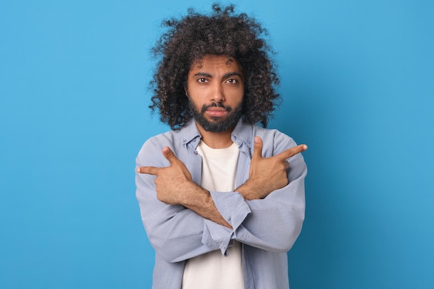 young arabian man points with index fingers both hands in different directions