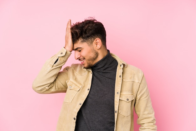 Young arabian man posing in a wall isolated forgetting something, slapping forehead with palm and closing eyes.