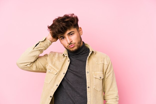 Young arabian man posing in a wall isolated tired and very sleepy keeping hand on head.