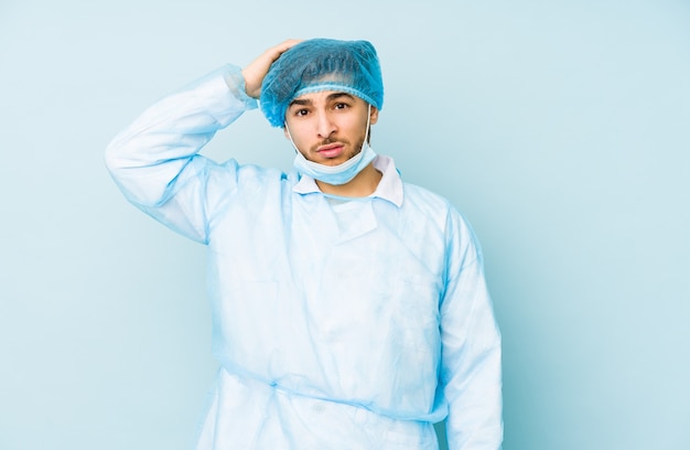 Young arabian surgeon man isolated against on a blue background being shocked, she has remembered important meeting.