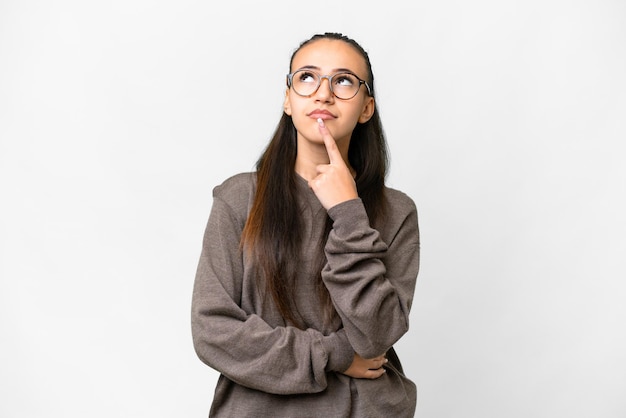 Young Arabian woman over isolated white background having doubts while looking up