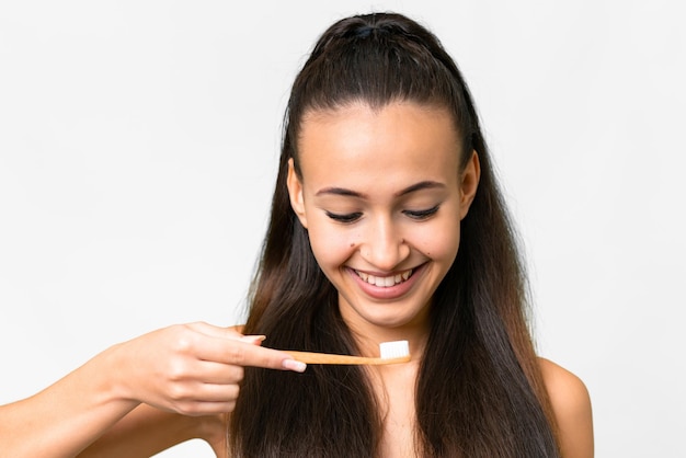 Young Arabian woman over isolated white background with a toothbrush