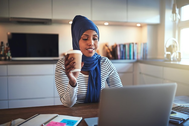 커피를 마시며 집에서 온라인으로 일하는 젊은 아랍 여성