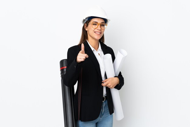 Young architect caucasian woman with helmet and holding blueprints