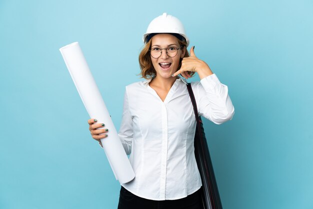 Young architect Georgian woman with helmet and holding blueprints isolated