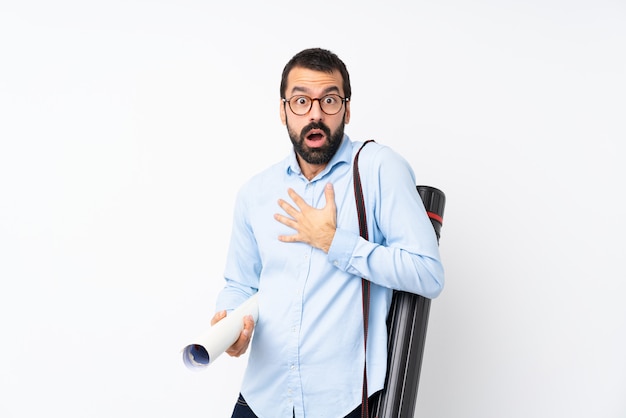 Foto giovane uomo dell'architetto con la barba sopra fondo bianco isolato sorpreso e colpito mentre sembrando giusto