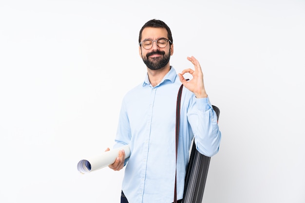 Giovane uomo dell'architetto con la barba sopra bianco isolato nella posa di zen