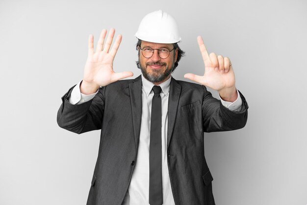 Young architect man with helmet over isolated background counting seven with fingers